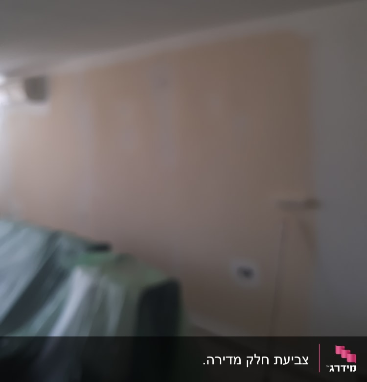 קיר צבוע חלקית עם רולר צביעה